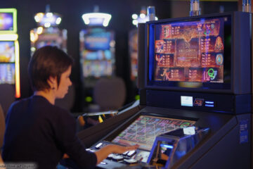 Frau am Spielautomaten im Casino